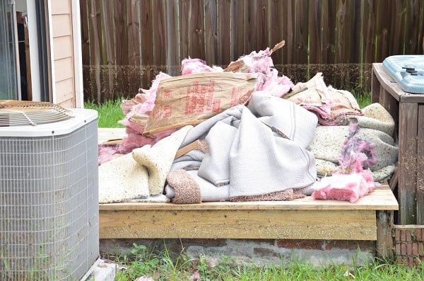 Home pulled up damaged carpet and insulation on back deck suggesting water damage/flood damage