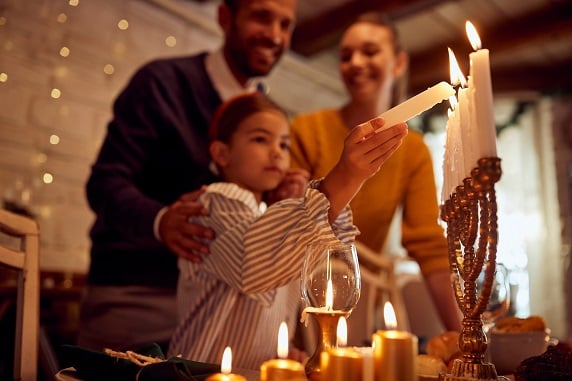 family lighting menorah candles