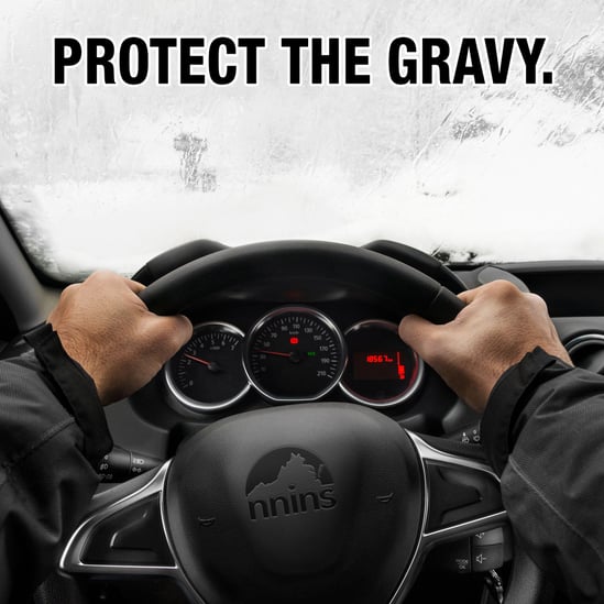 man hands griping steering wheel driving in snowy weather with title Protect the Gravy