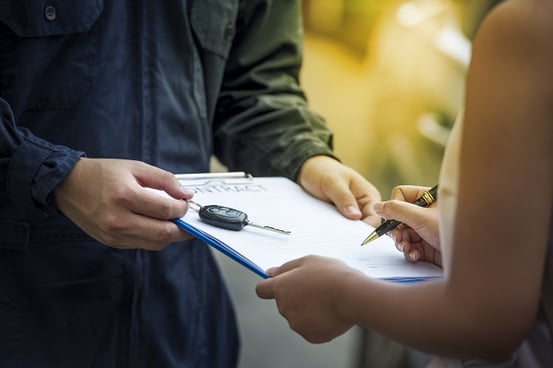 rental car man giving paper contract to woman