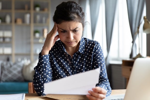 woman with furrowed brow looking at paper