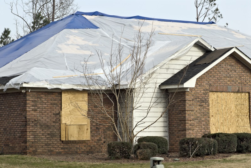 Home with hurricane damage and tarp over roof