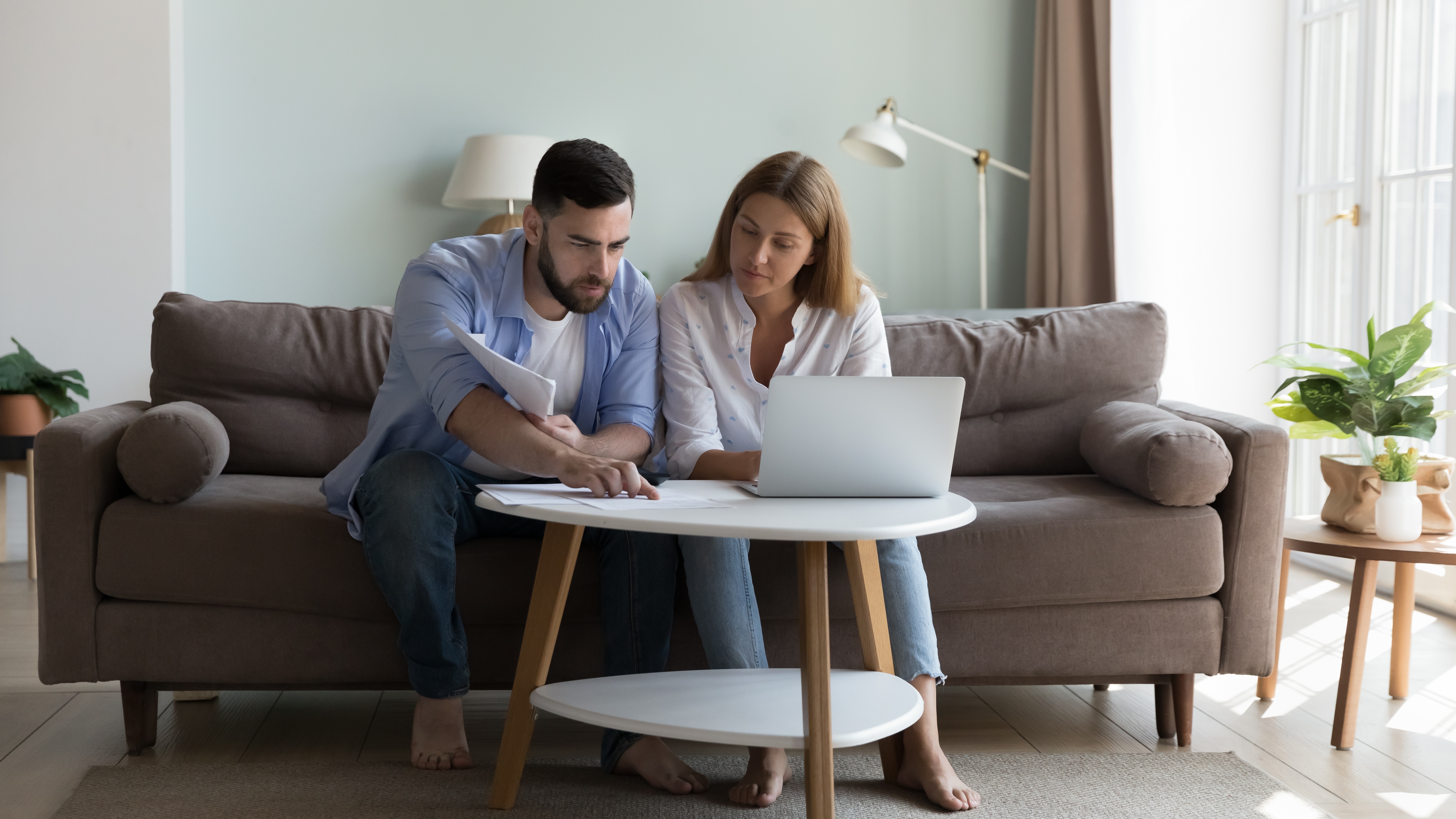 Serious couple over laptop looking at documents